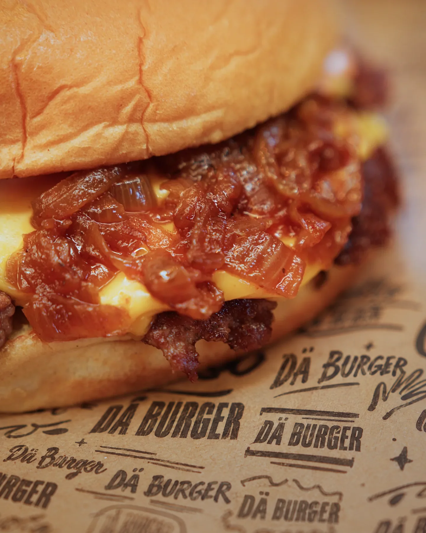 A smashburger with caramelised onions on the red tray with DÄ burger paper