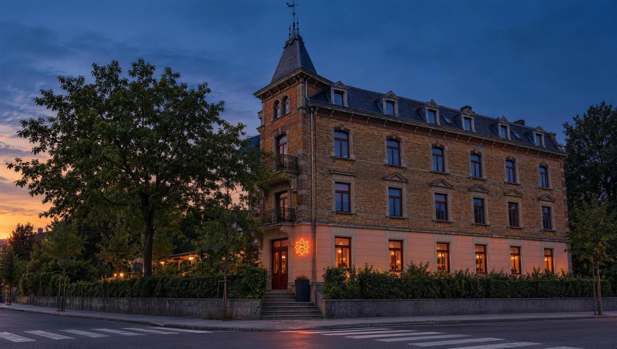 Das Eckhaus an der Bahnhofstrasse 102 mit Türmchen am Abend, erhöht hinter Mauer und Hecke, am Erdgeschoss leuchtet ein oranger Neon-Stern