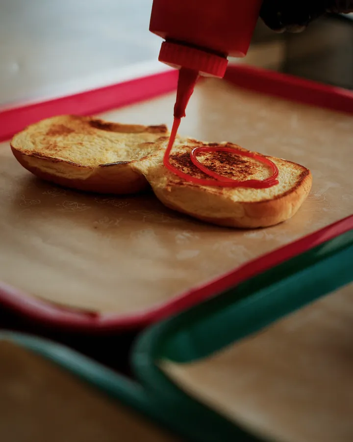 Ketchup, Senf, Sauce und Salat auf den Bun, dann der Patty mit Cheddar und Homemade Sauce darüber