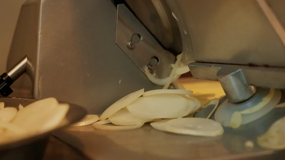 Onions being sliced, caramelised on the plate and spooned onto the melted cheddar